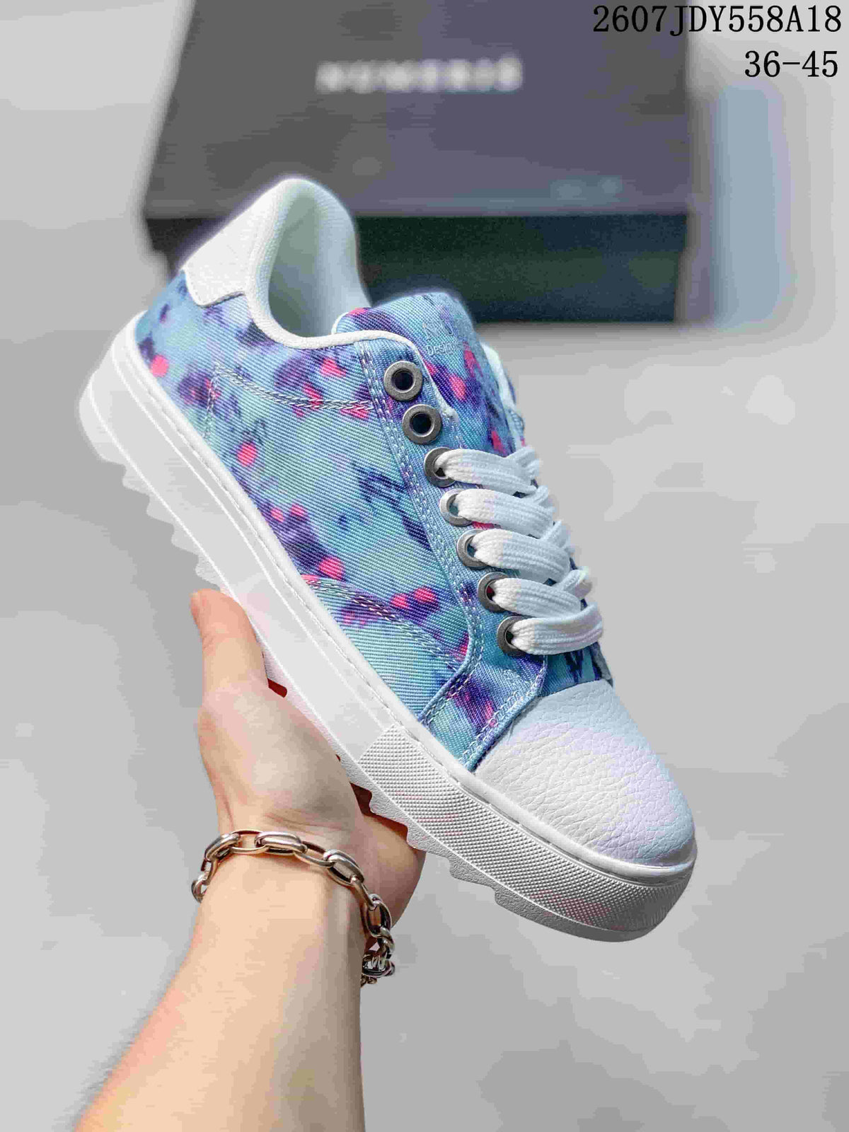 Light blue NUMERIS low-top sneaker with a colorful floral-style print, white laces and a white raised sole; image shows size range 36-45.