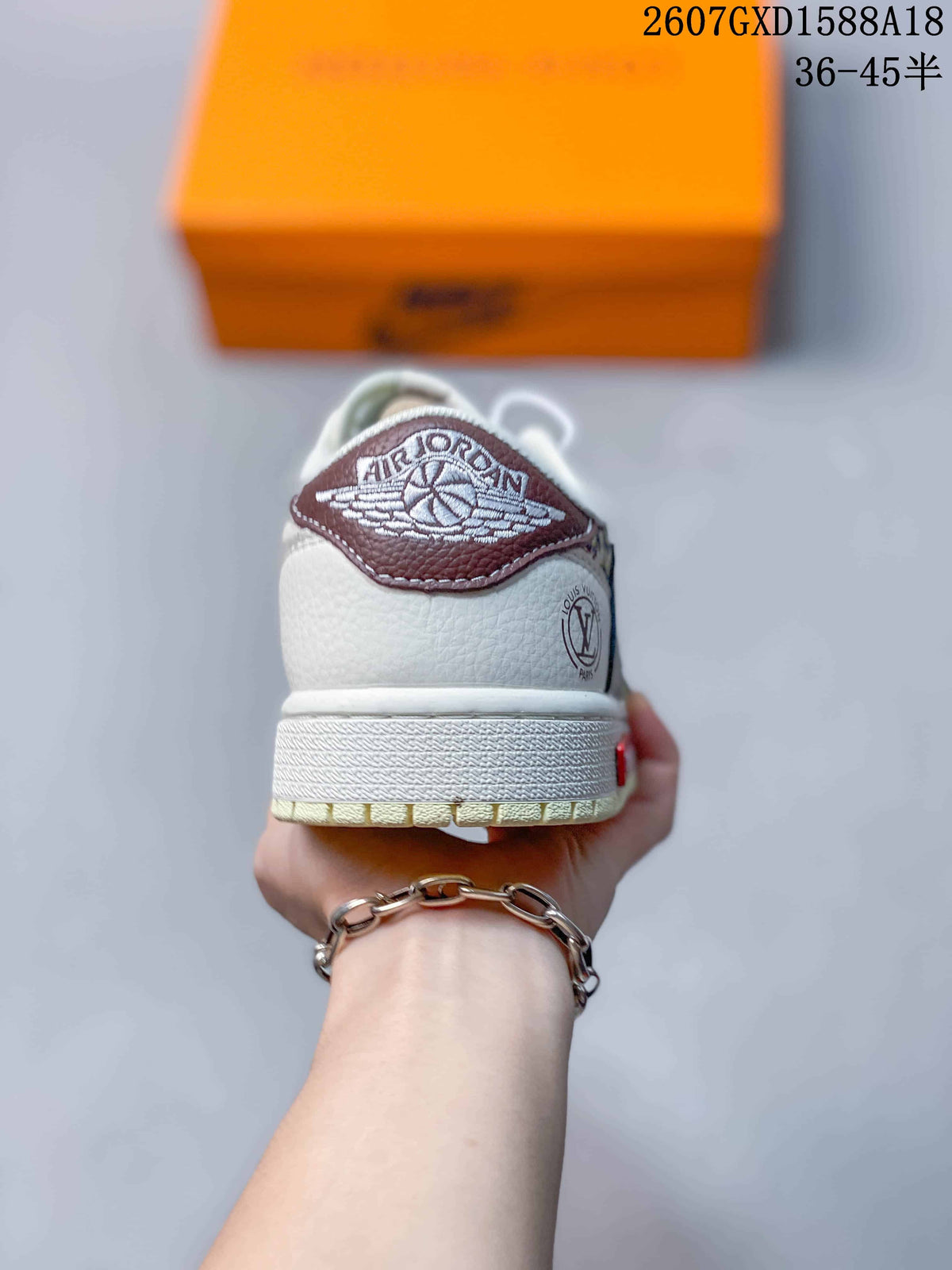 Rear view of the sneaker showing a brown Air Jordan-style heel label, white heel panel, and pale outsole.