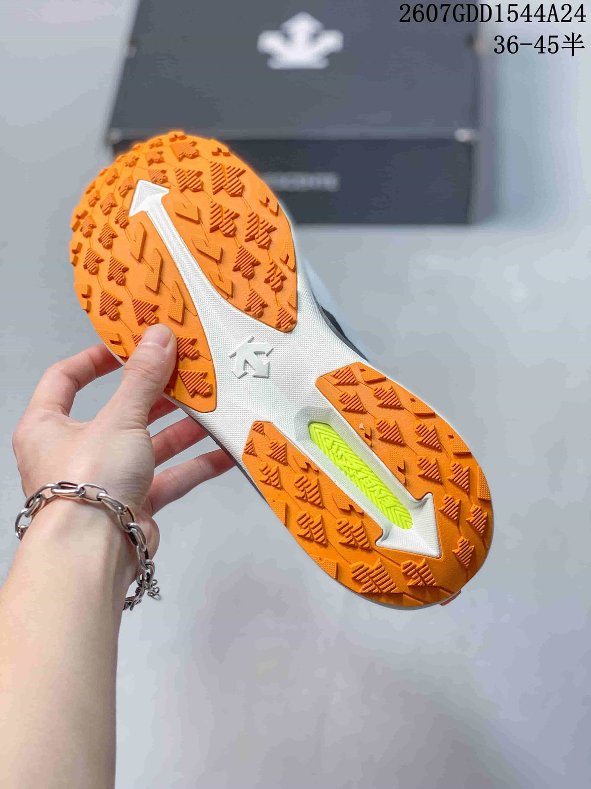 Close view of the orange patterned outsole with white structural sections and a bright lime-green insert.