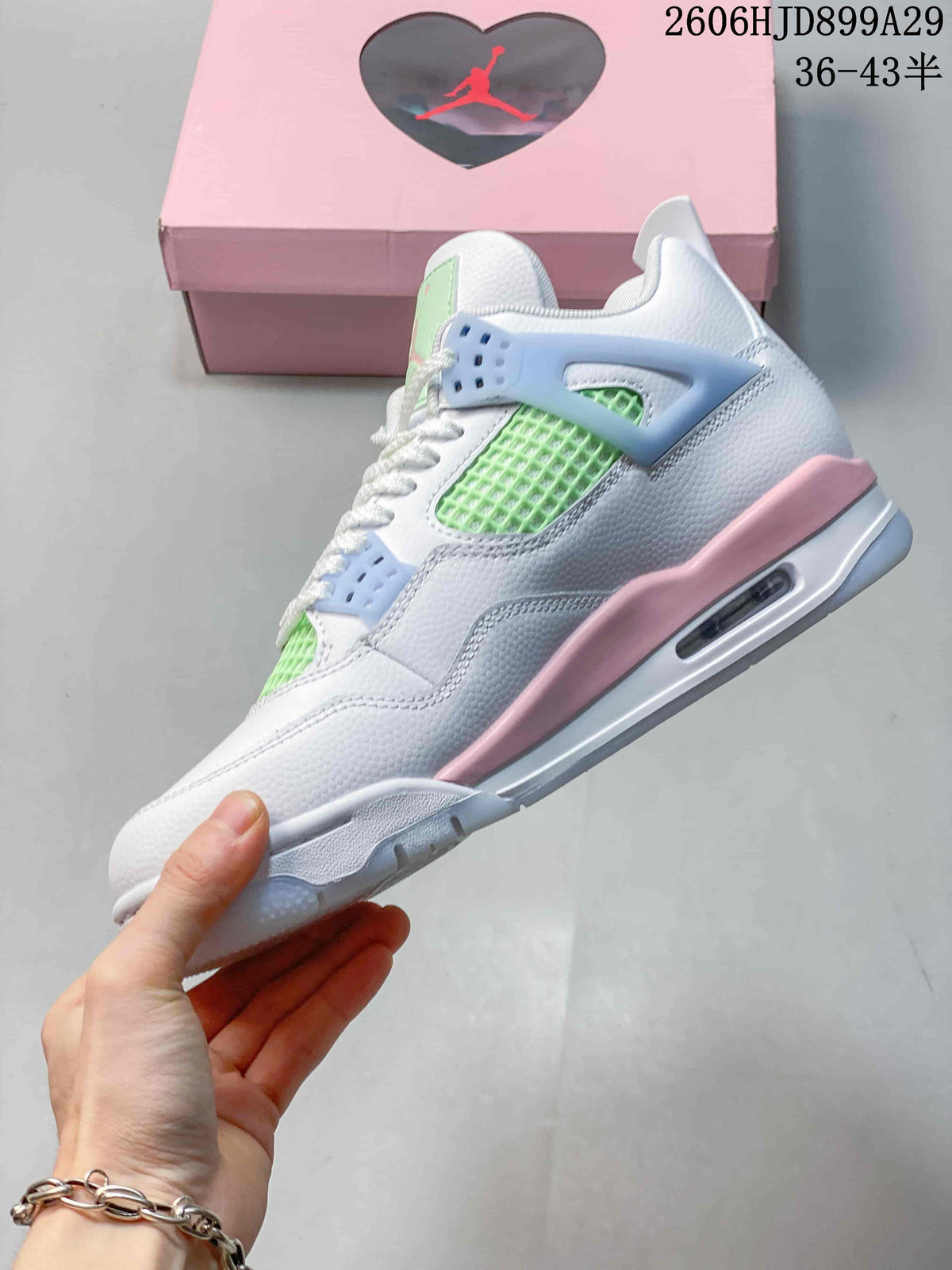 Side view showing the white upper, mint green mesh panels, pale blue lace supports, pink accents, and visible air unit