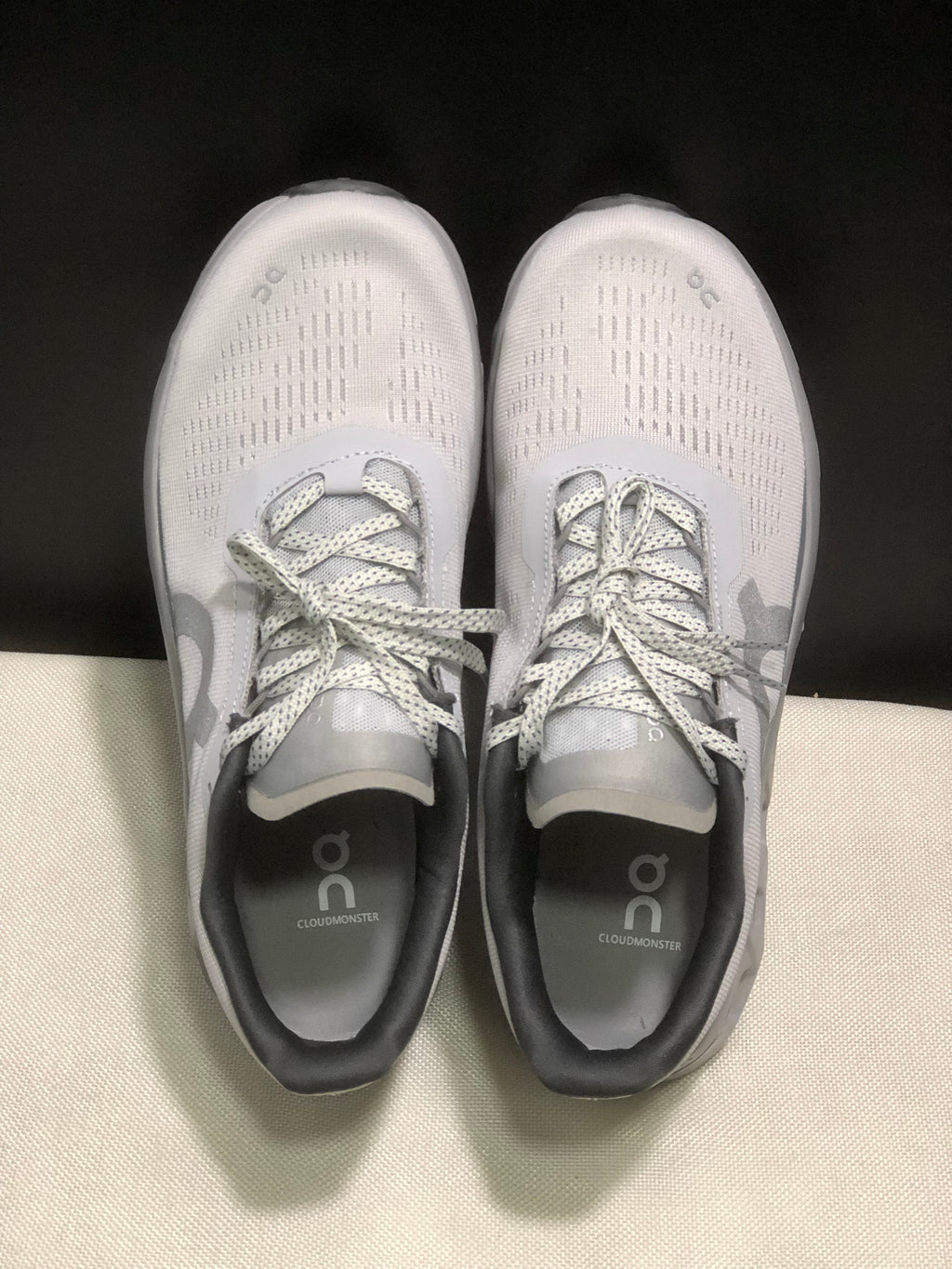 Top-down view showing the patterned light gray uppers, laces, padded collars, and Cloudmonster footbed branding.