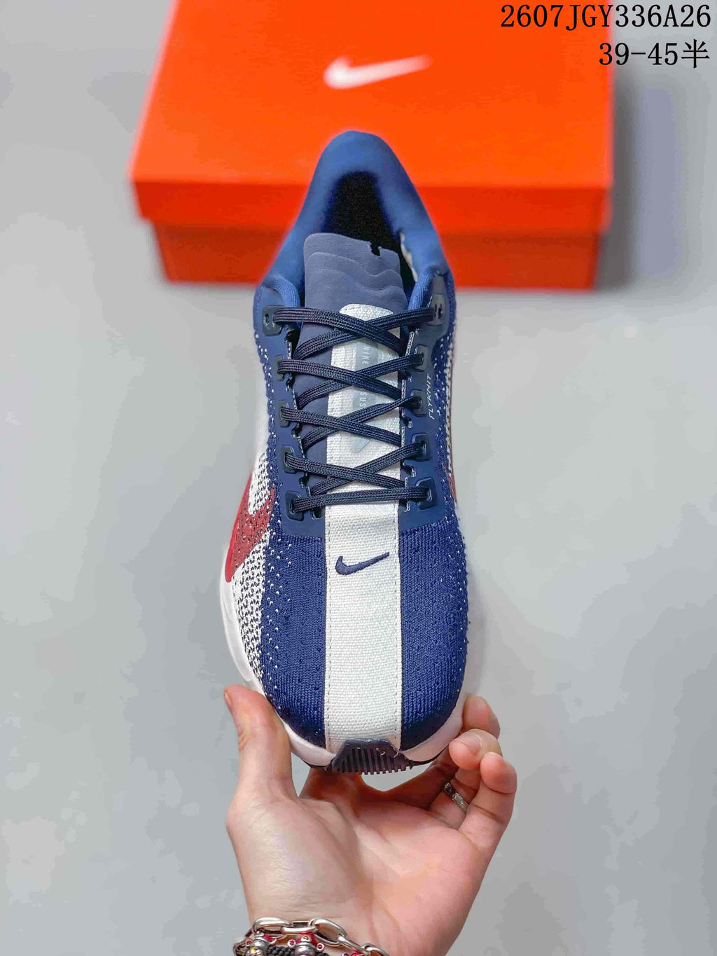Top view showing the navy and white knit upper, dark laces, tongue and toe branding.