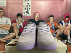 Front view of light gray-white low-top sneakers showing lace-up fastening and perforated toe panels.