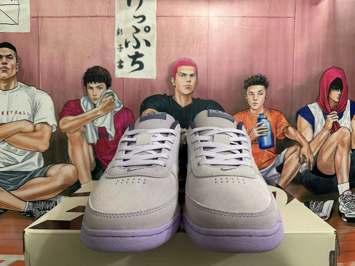 Front view of light gray-white low-top sneakers showing lace-up fastening and perforated toe panels.