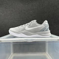 Gray and white low-top Nike shoe with a white Swoosh and signature-style heel detail