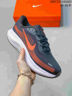 Angled side view of a charcoal Nike Vomero running shoe with orange accents