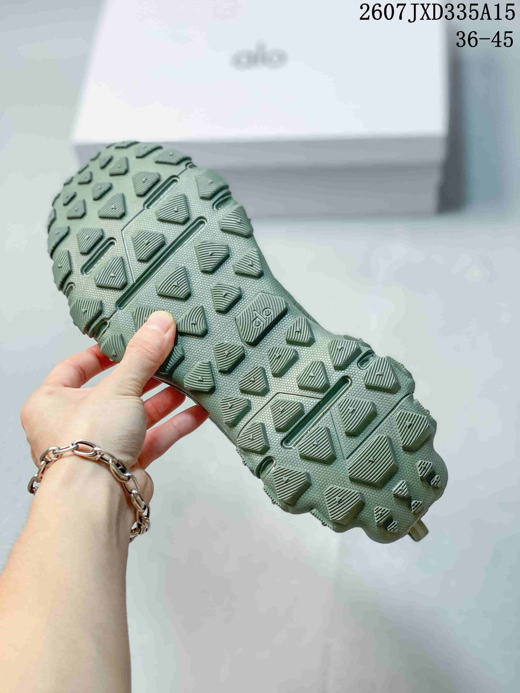 Close-up of the green sneaker outsole showing its geometric raised tread pattern and deep grooves.