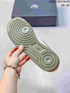 Underside of the sneaker showing circular tread details and sage-green outsole