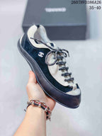 Three-quarter side view of the black-and-white low-top trainer with the side logo detail visible.