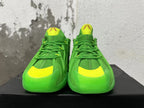 Front view of green Adidas sneakers with bright yellow toe and tongue accents