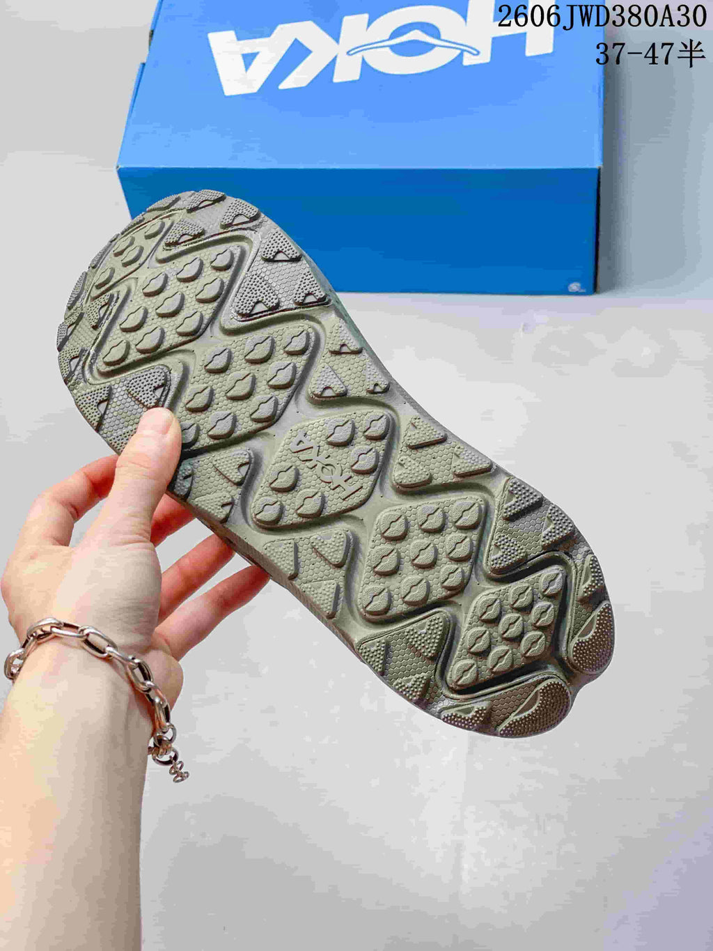 Close-up of the patterned outsole on an olive-toned mule sneaker