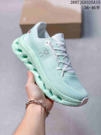 Angled side view of the mint green and white On Cloudtilt sneaker showing the mesh-like upper and sculpted sole.