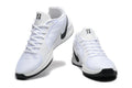 Pair of white low-top basketball shoes with black Swooshes and black outsole