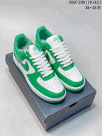 Green-and-white Nike Air Force 1 sneakers displayed on a shoe box, with white laces and a visible box label showing the size range text.