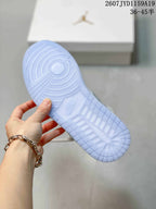 Underside view of a sneaker showing a translucent light-blue outsole with circular and textured traction patterns.