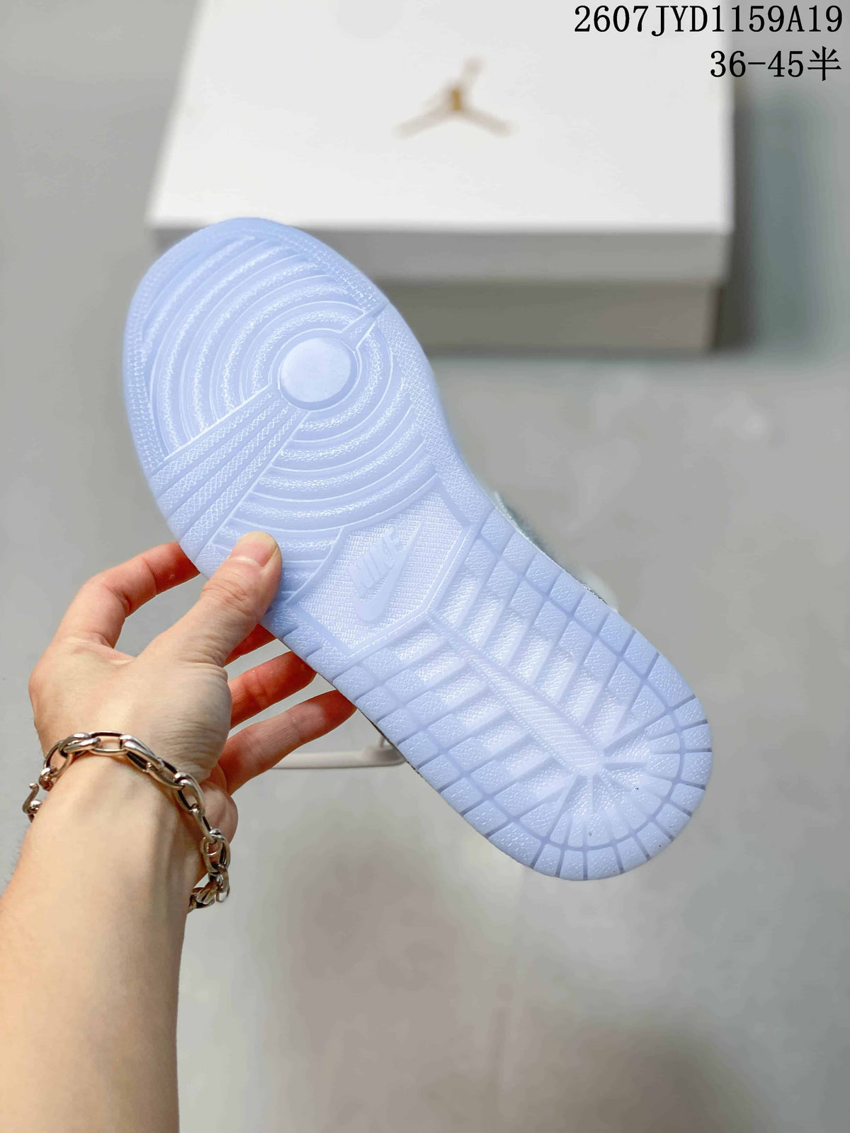 Underside view of a sneaker showing a translucent light-blue outsole with circular and textured traction patterns.