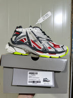Balenciaga Runner sneaker displayed on its box, with the label showing style code 677403 W3RB6 9167, color code BLK/WHI/RED/FLUO YEL and size E 40.