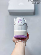 Rear view of the white sneaker showing purple branding details on the heel and outsole.