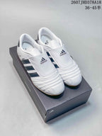 Pair of white adidas sneakers featuring tongue covers with adidas branding, dark side stripes and quilted toe panels.