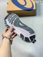 Bottom view of a navy and white ASICS sneaker showing the segmented dark outsole tread and white midsole.