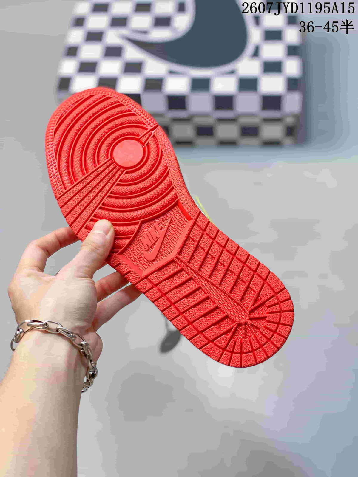 Close-up of the red rubber outsole showing circular and geometric traction patterns.