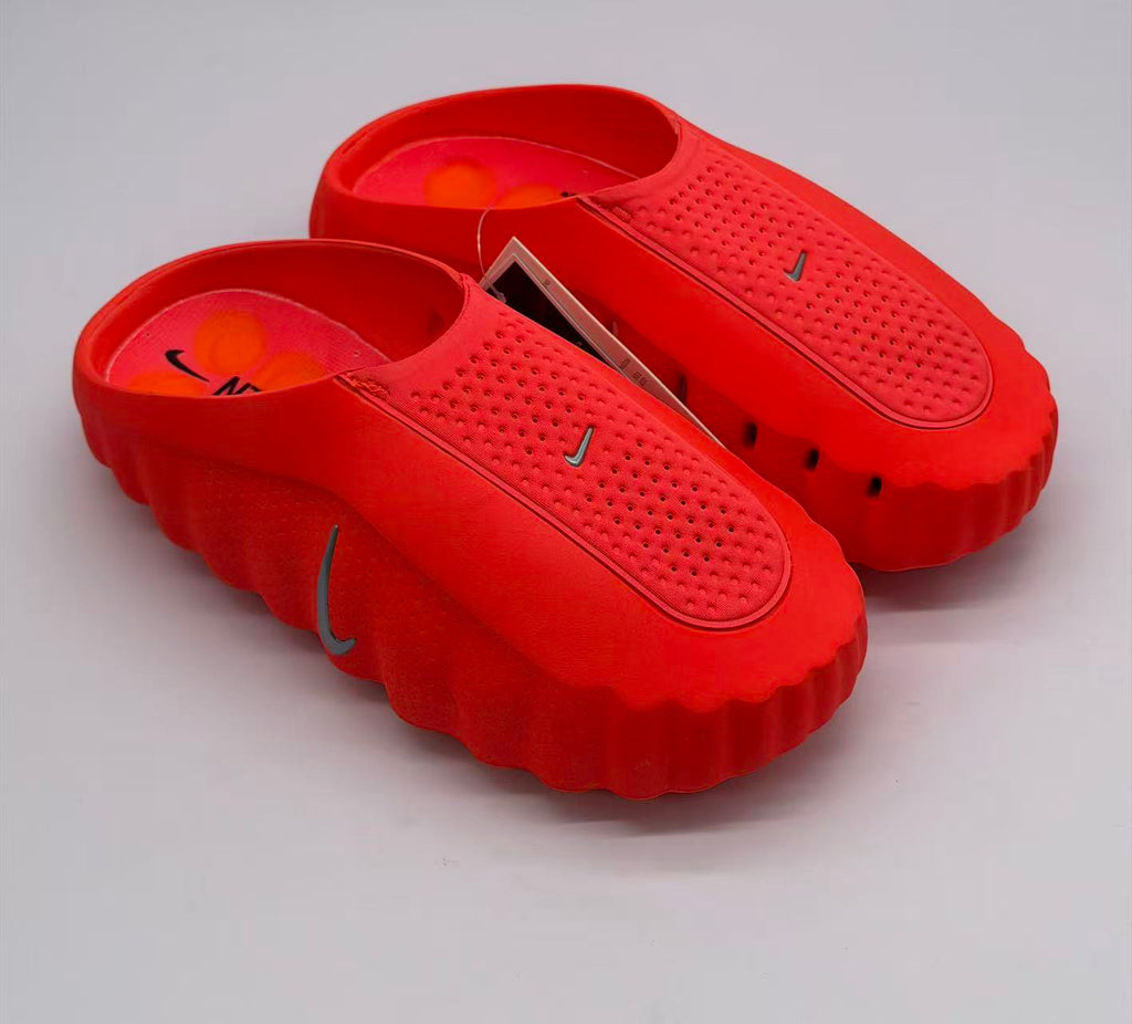 Pair of orange-red Nike slides viewed from above and at an angle.