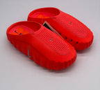 Pair of orange-red Nike slides viewed from above and at an angle.