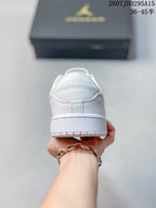 Rear view of the white sneaker showing Jordan lettering on the heel and the layered outsole.