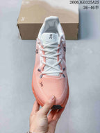 Top view of the pink and coral sneaker showing the light tongue, white laces, textured upper, and On branding.
