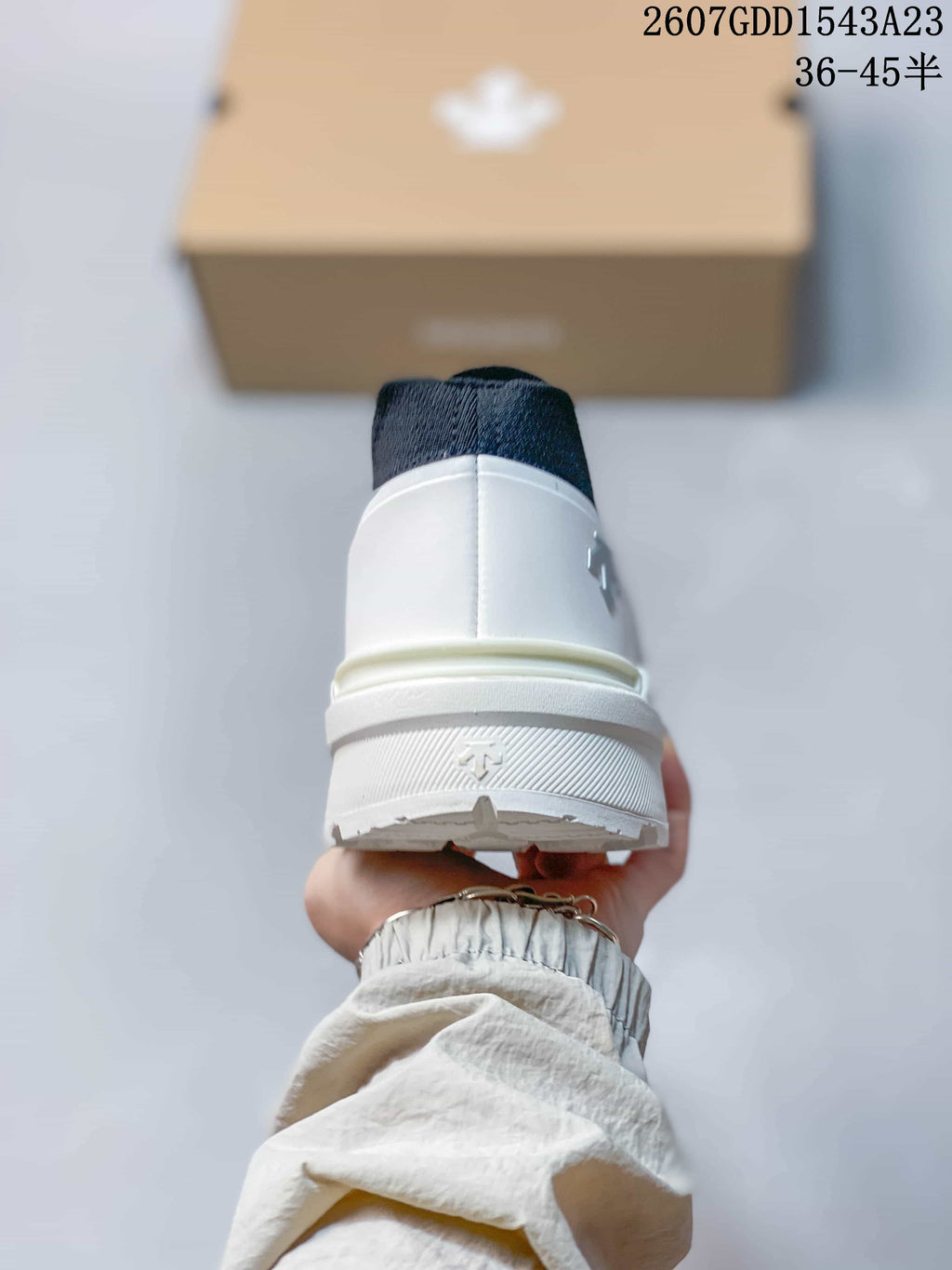 Rear view showing the white heel counter, navy collar, and raised sole