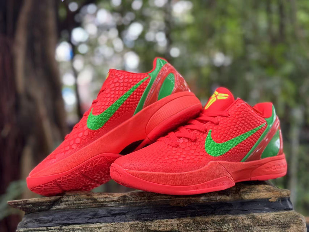 Pair of red Nike Kobe 6 basketball shoes with green accents