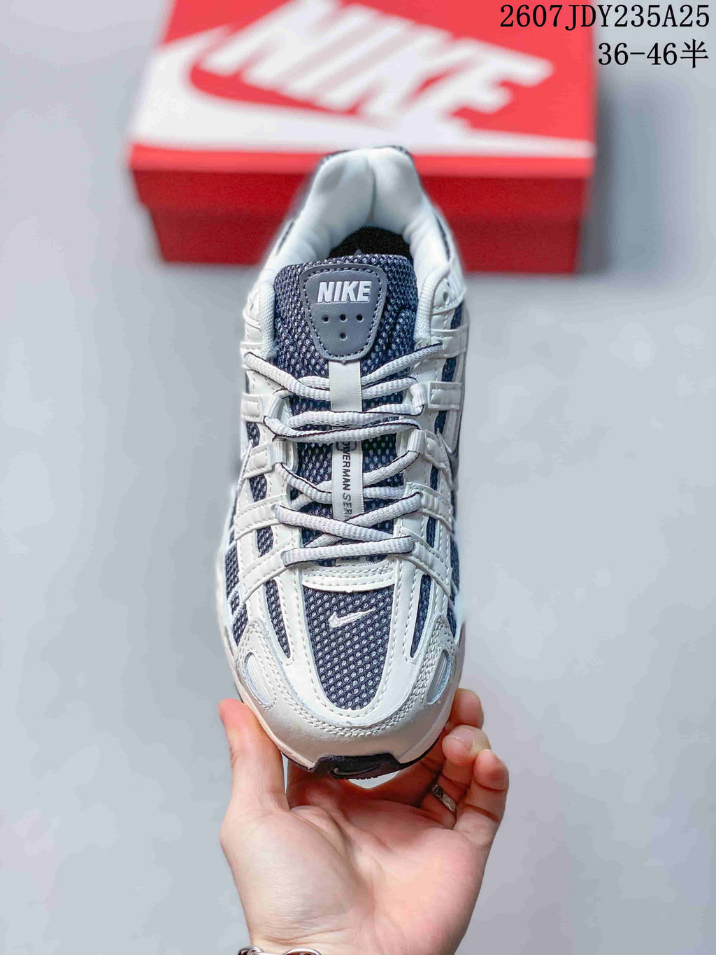 Top view of the sneaker showing the dark mesh-style tongue and layered lace area.