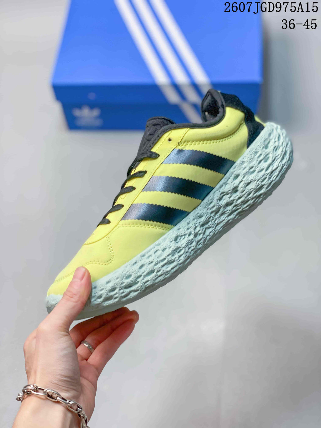Side view highlighting the yellow upper, black three-stripe detailing, and textured outsole.