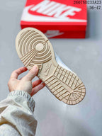 Bottom view of a beige rubber outsole with circular and grid traction patterns.