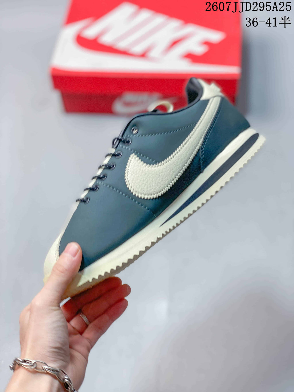 Side profile of the navy and cream sneaker showing the contrast Swoosh, stitched panels, and layered sole.