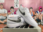 White Nike sneakers displayed at an angle, showing the patterned Swoosh and perforated upper
