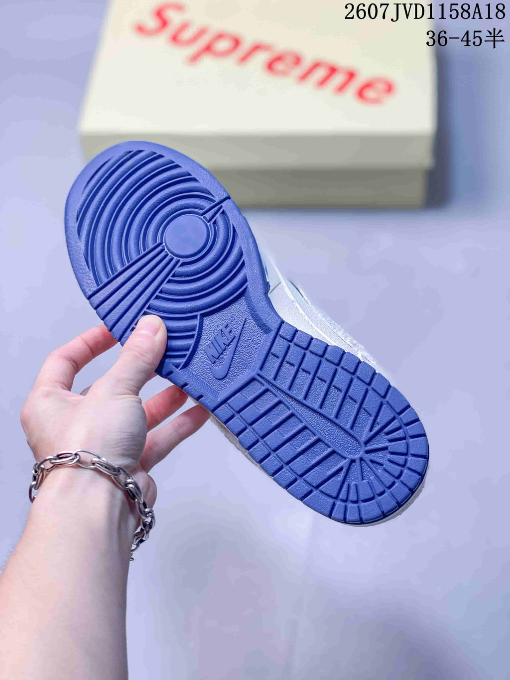 Bottom view of a sneaker showing the blue rubber outsole and circular traction pattern.