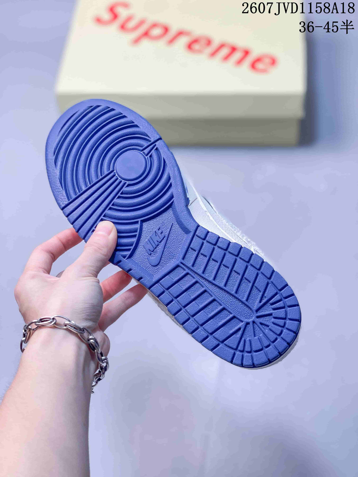 Bottom view of a sneaker showing the blue rubber outsole and circular traction pattern.