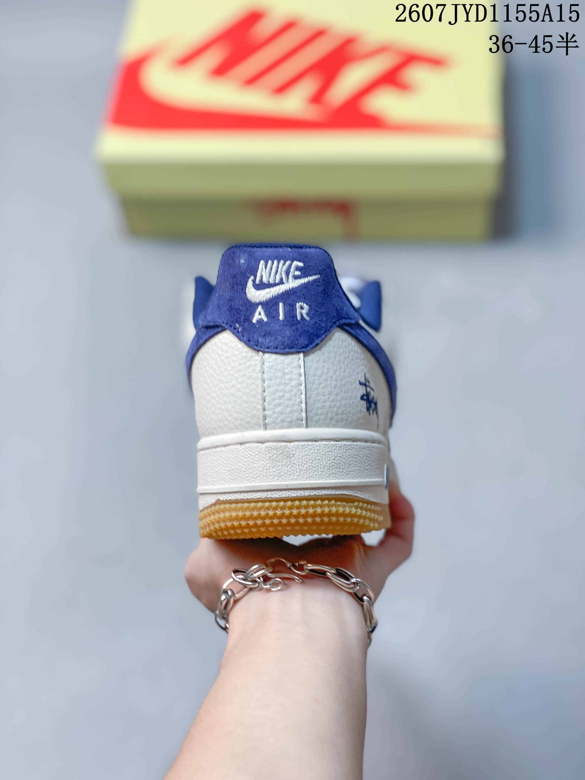 Rear view of a Nike Air Force 1 sneaker showing the blue collar, white heel panel and gum outsole.