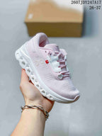 Angled side view highlighting the On side logo, pale pink upper, and segmented white outsole.