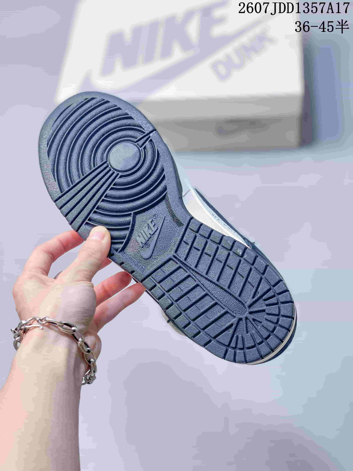 Underside view of the sneaker showing the patterned navy rubber outsole.