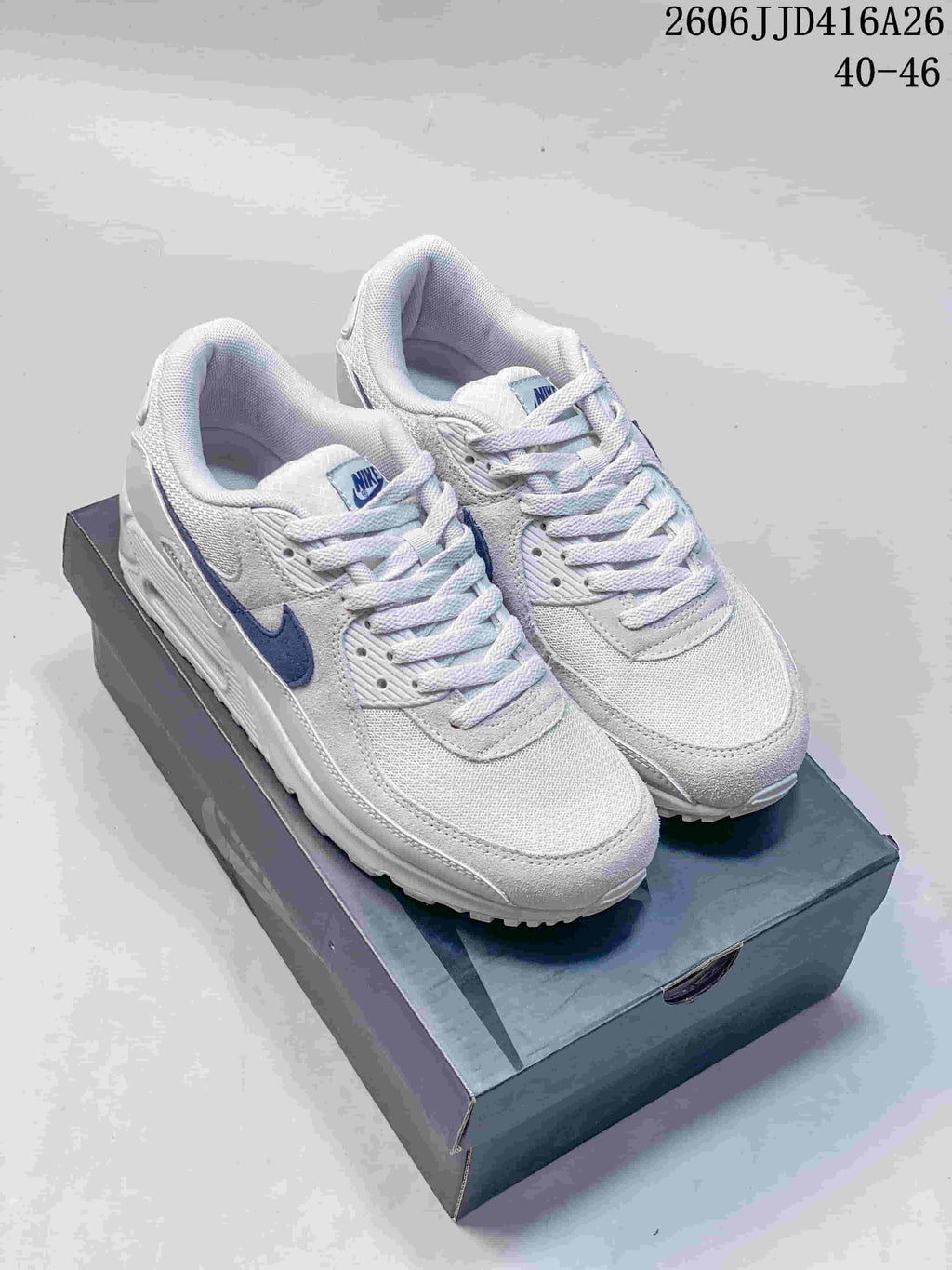 Pair of white and blue Nike Air Max 90 sneakers displayed on a shoebox; the image also shows the text "2606 JJD416A26" and "40–46".
