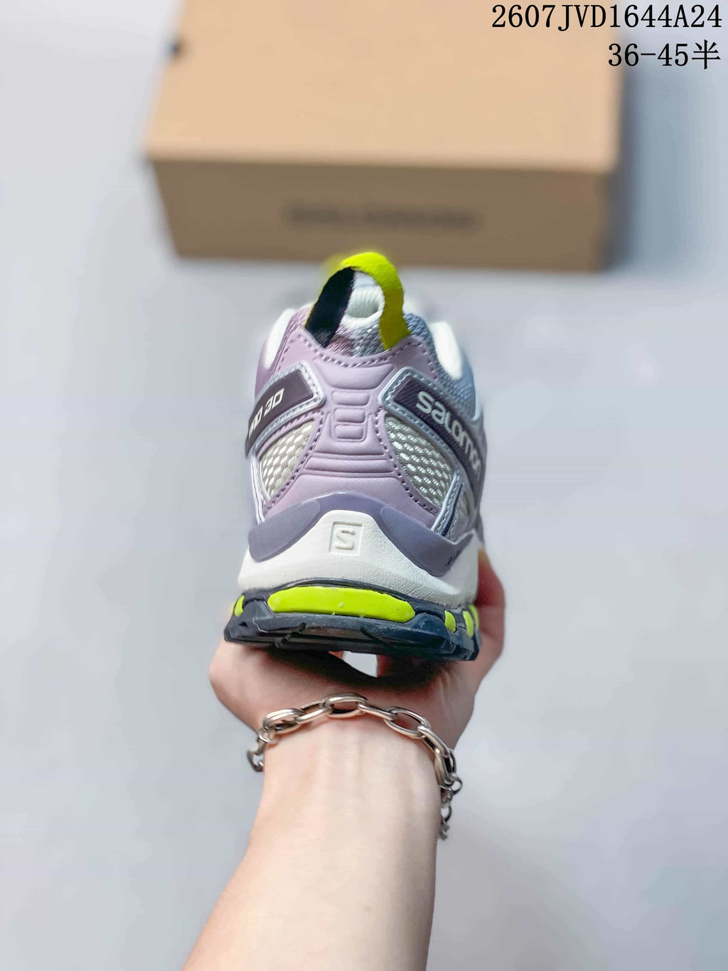 Rear view of the Salomon sneaker showing the padded heel, branding and neon yellow outsole accents.