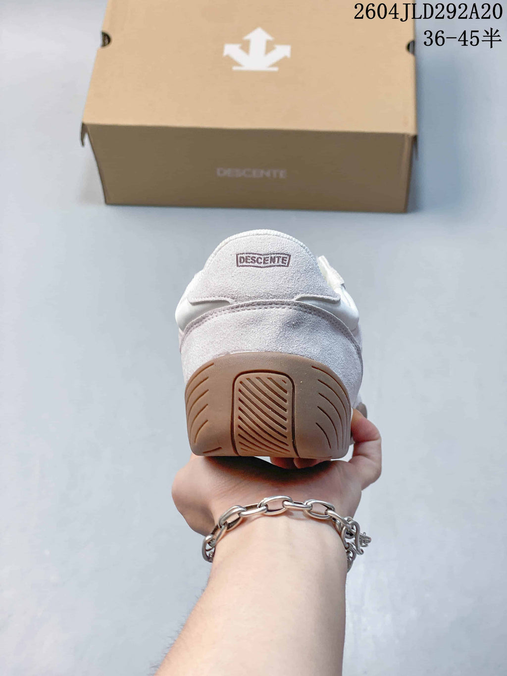 Rear view showing the heel panel, DESCENTE branding and gum-colored outsole.