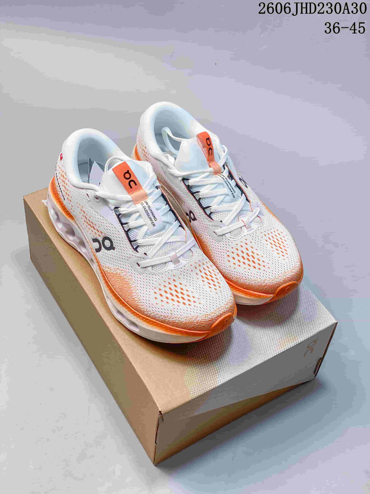 Pair of white and orange On Cloudtilt sneakers on a shoebox