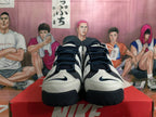 Front view of white and dark navy Nike basketball shoes with lace-up closures.