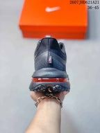 Rear view of the sneaker showing the padded heel, dark upper, red cushioning element, and segmented outsole.