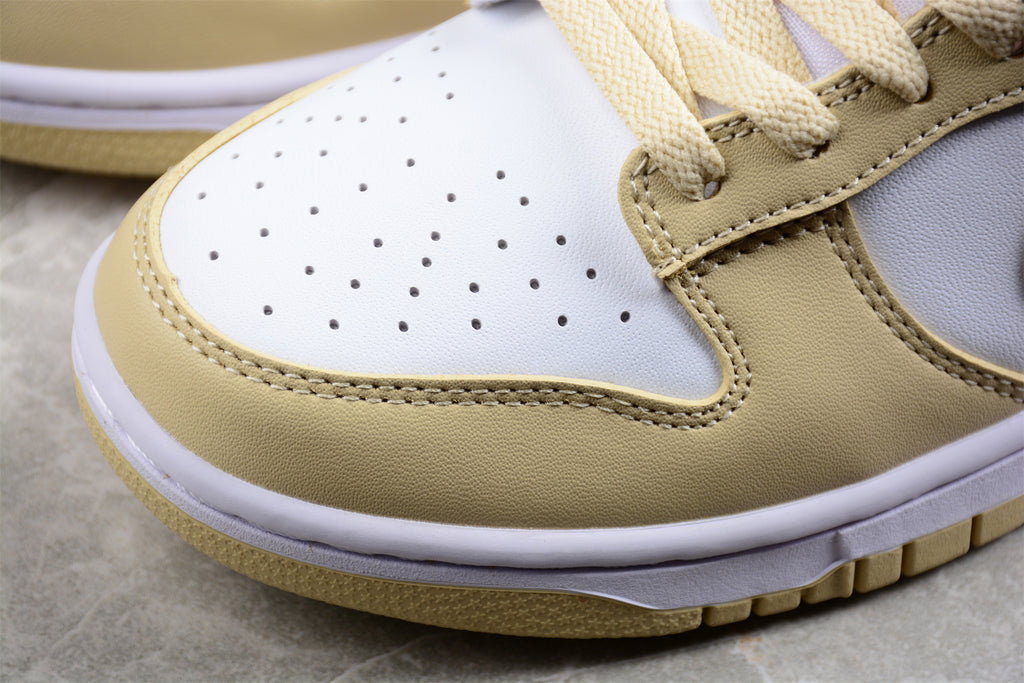 Close-up of the perforated white toe box, cream overlay, stitching, and layered sole.