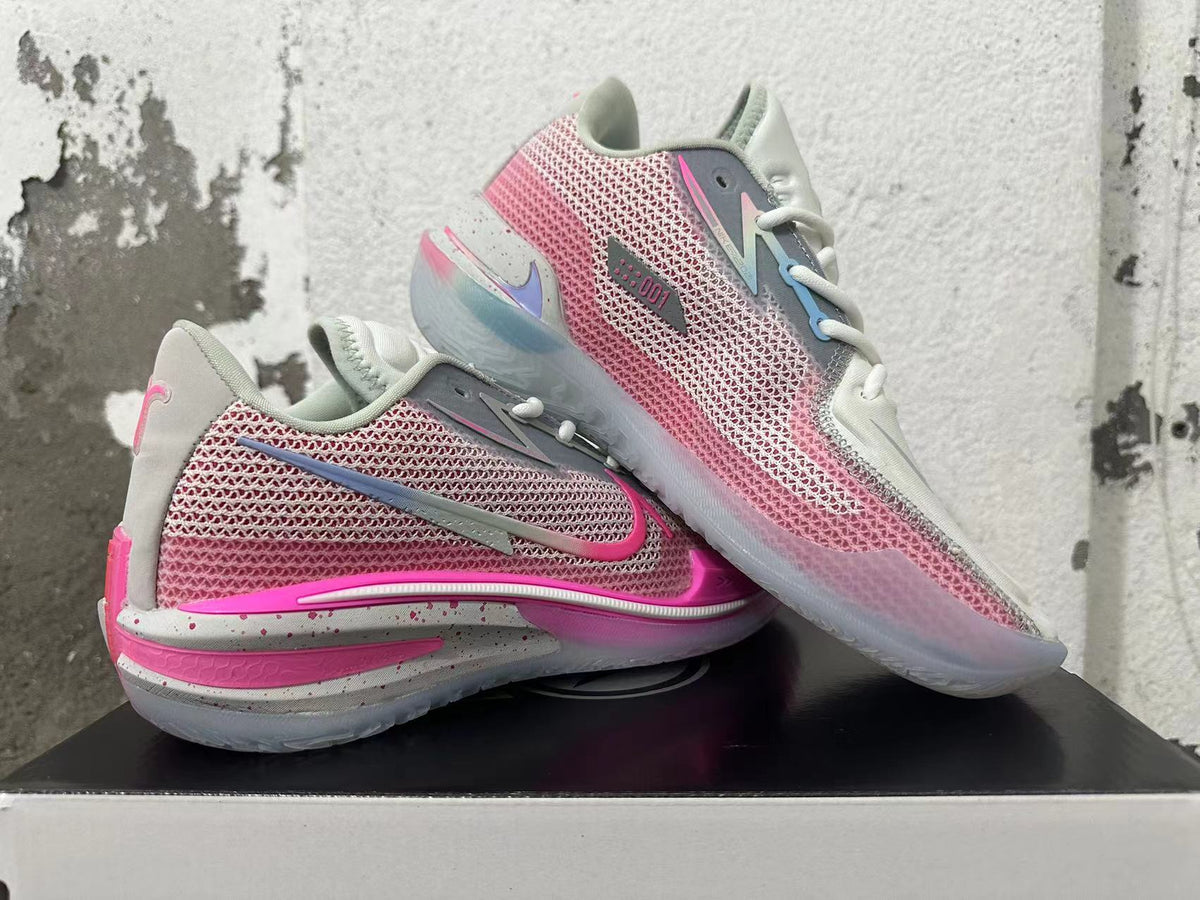 Pair of pink and grey Nike GT Cut 3 basketball shoes shown at an angle