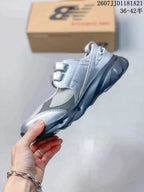 Side view of the silver low-top sneaker with mesh panels, layered overlays and dual straps.